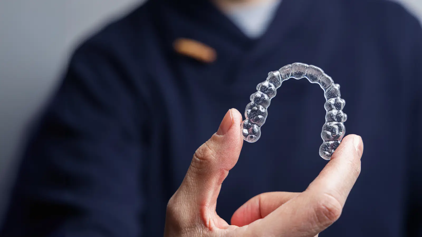 dentist holding invisalign clear aligner